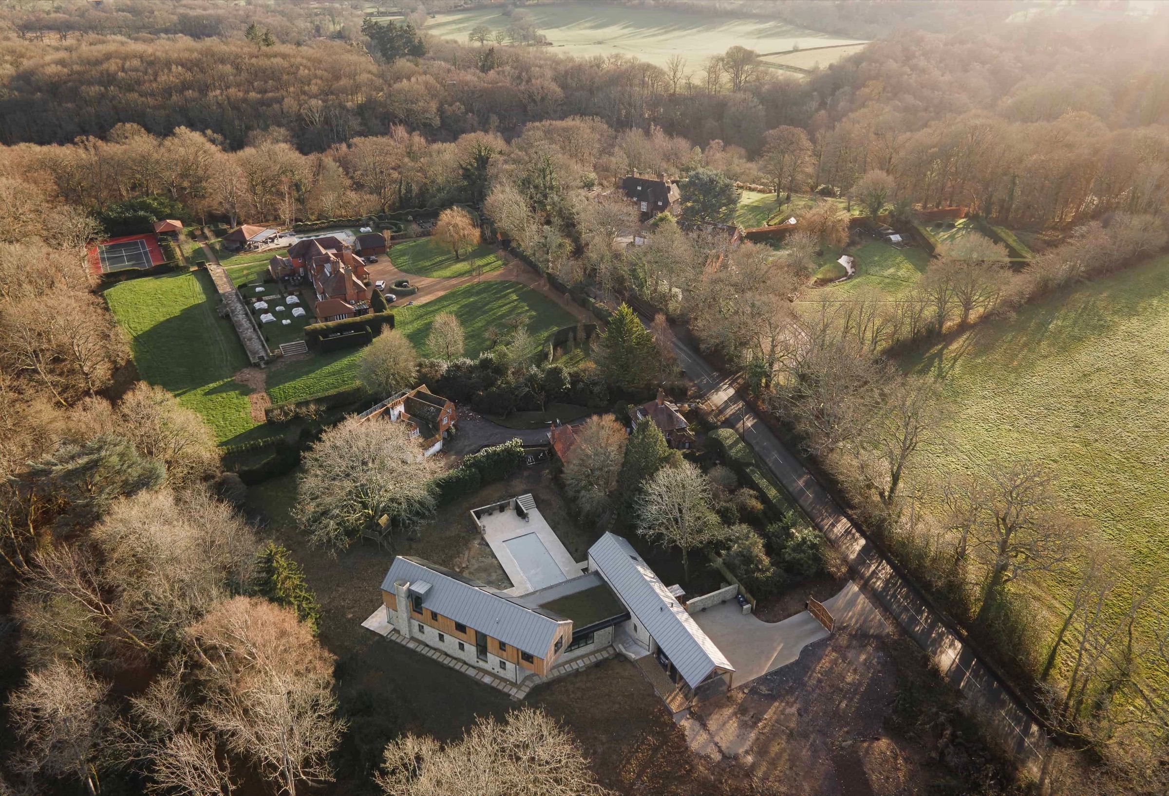 Hazelbridge Cottage aerial view showing timber-clad home nestled in Surrey Hills woodland